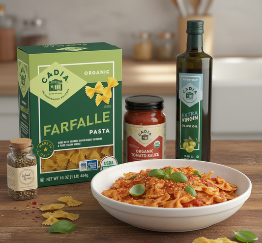 Pasta dish with Cidia Organic Farfalle pasta, tomato sauce, olive oil, and spices on a wooden table.